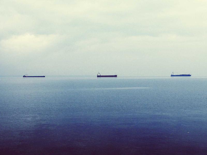 Trois cargos naviguant sur une mer calme.